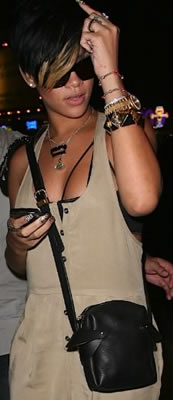 Rihanna carries a cross body leather handbag.